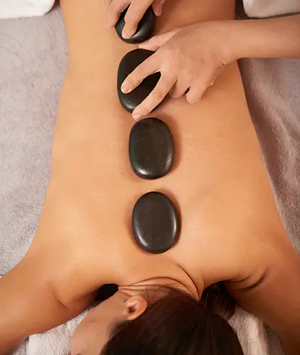 young woman having hot stone therapy massage spa salon 1